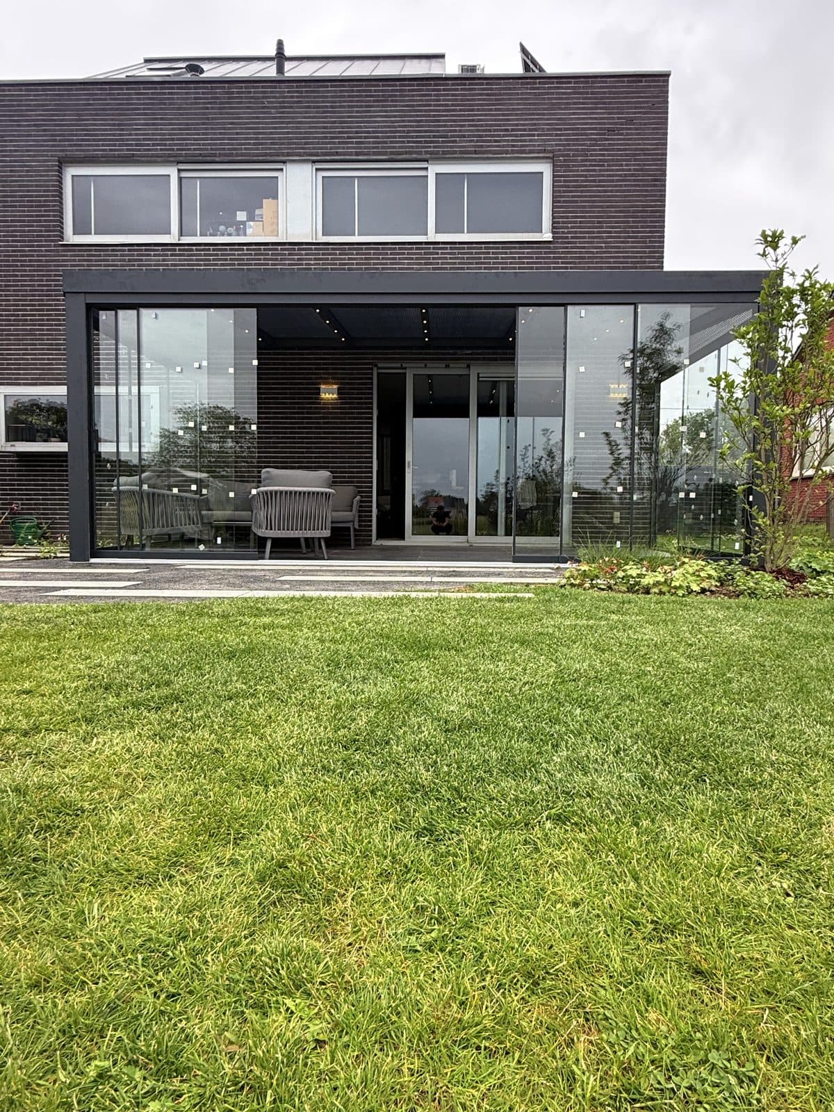 De overkapping over de volle breedte van de achtergevel