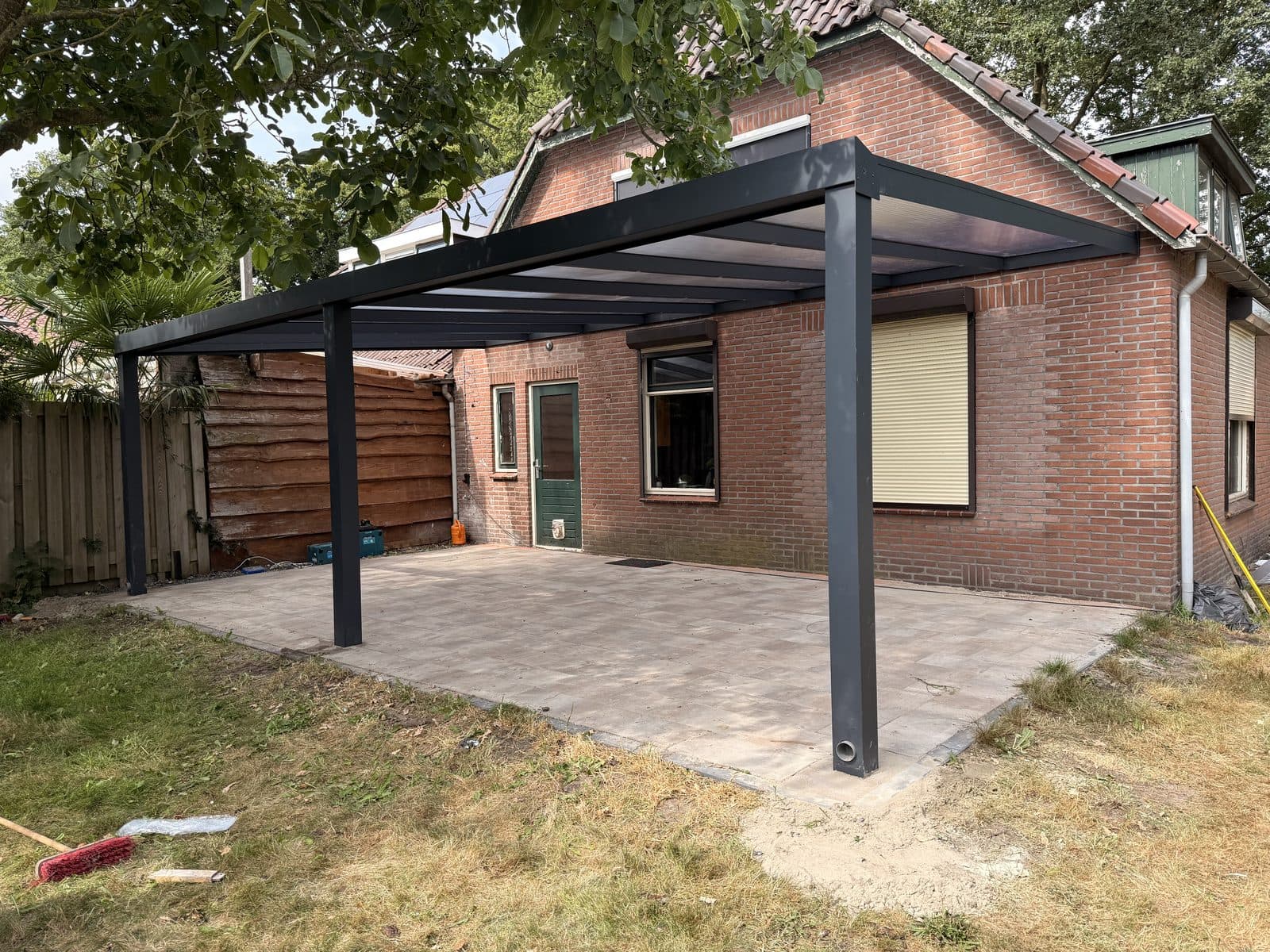 Aluminium terrasoverkapping met polycarbonaat dak, geplaatst in een tuin