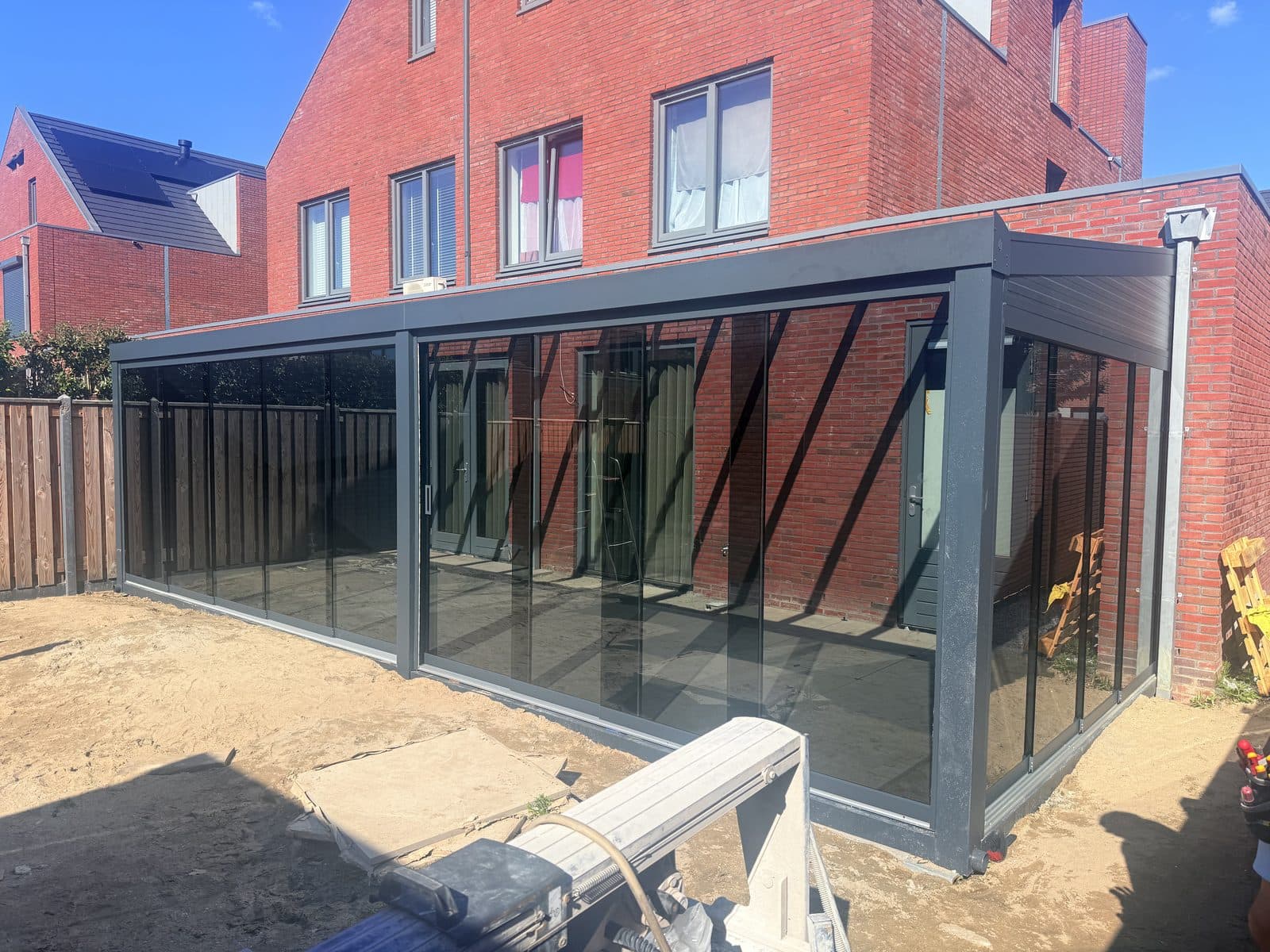 Overkapping met glazen schuifwanden aan een nieuwbouwwoning