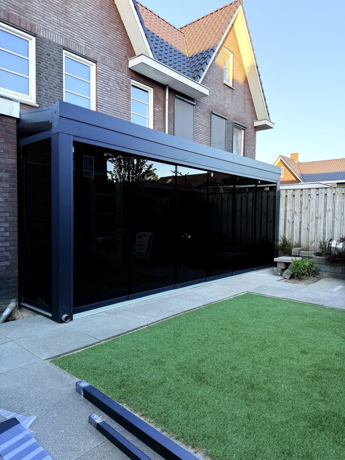 Overkapping met glazen schuifwanden aan een woning met puntgevel