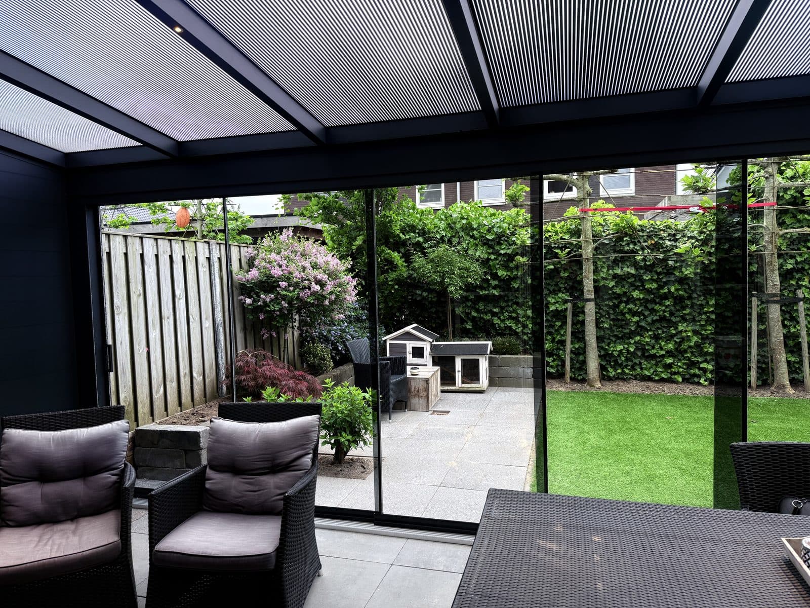 Uitzicht op de tuin vanonder de overkapping