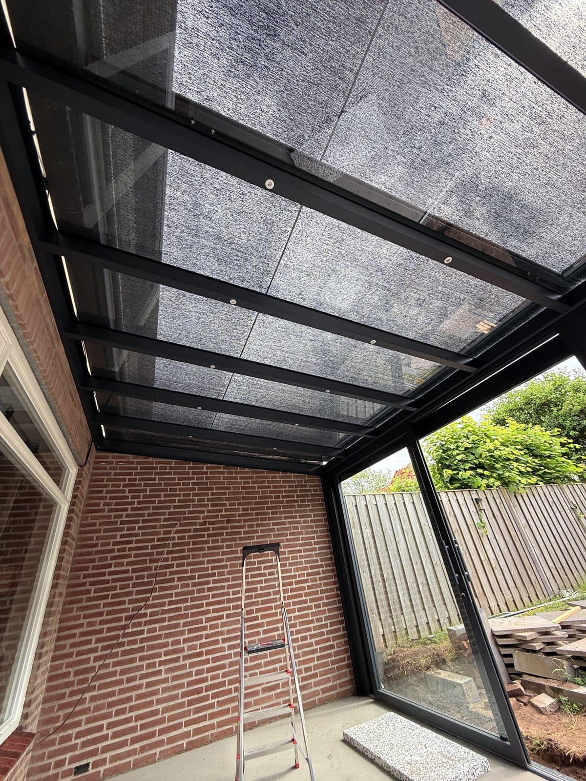 Overkapping met screen onder het glasdak