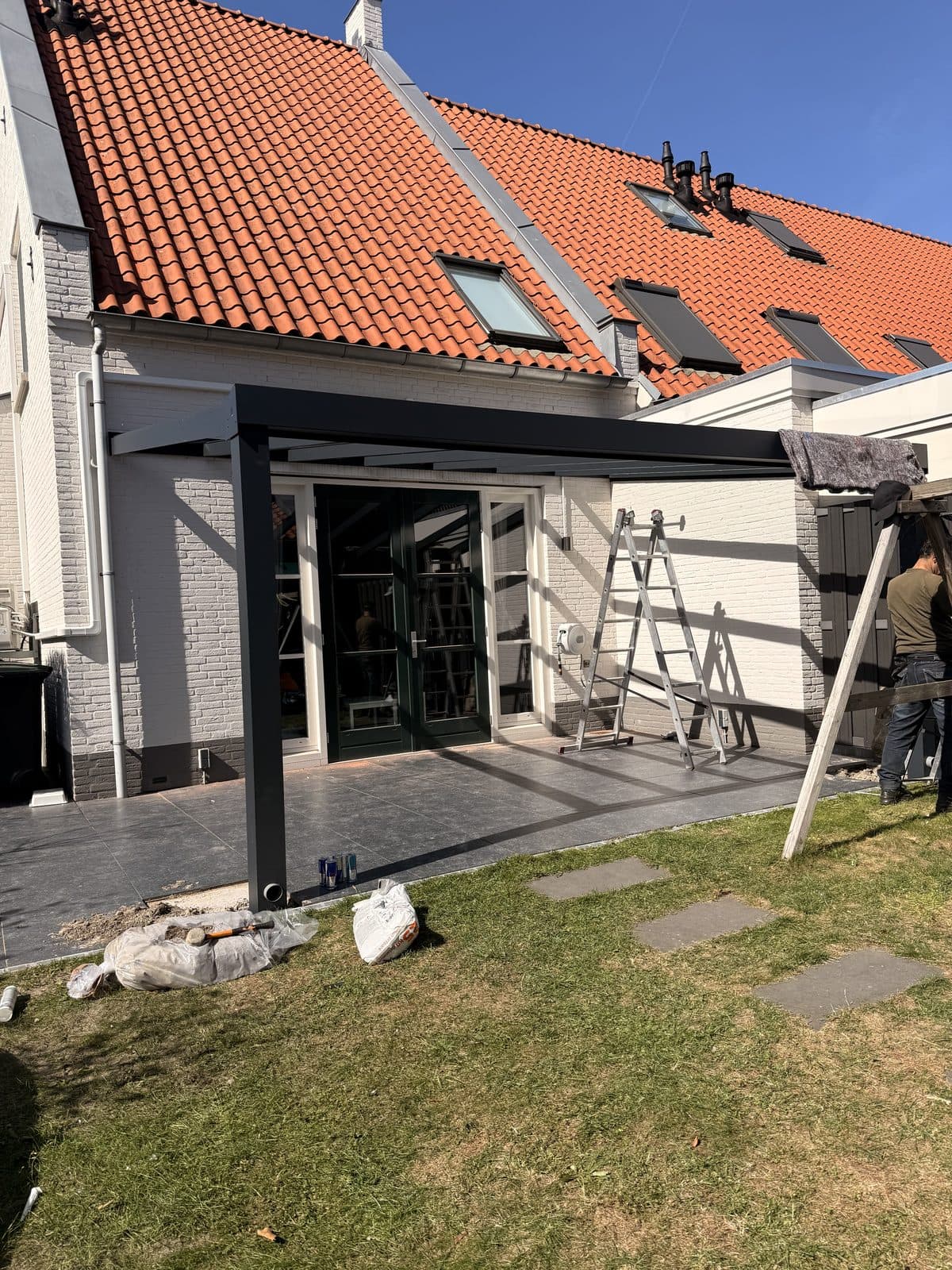 Overkapping aan een wit gestucte woning tijdens de montage