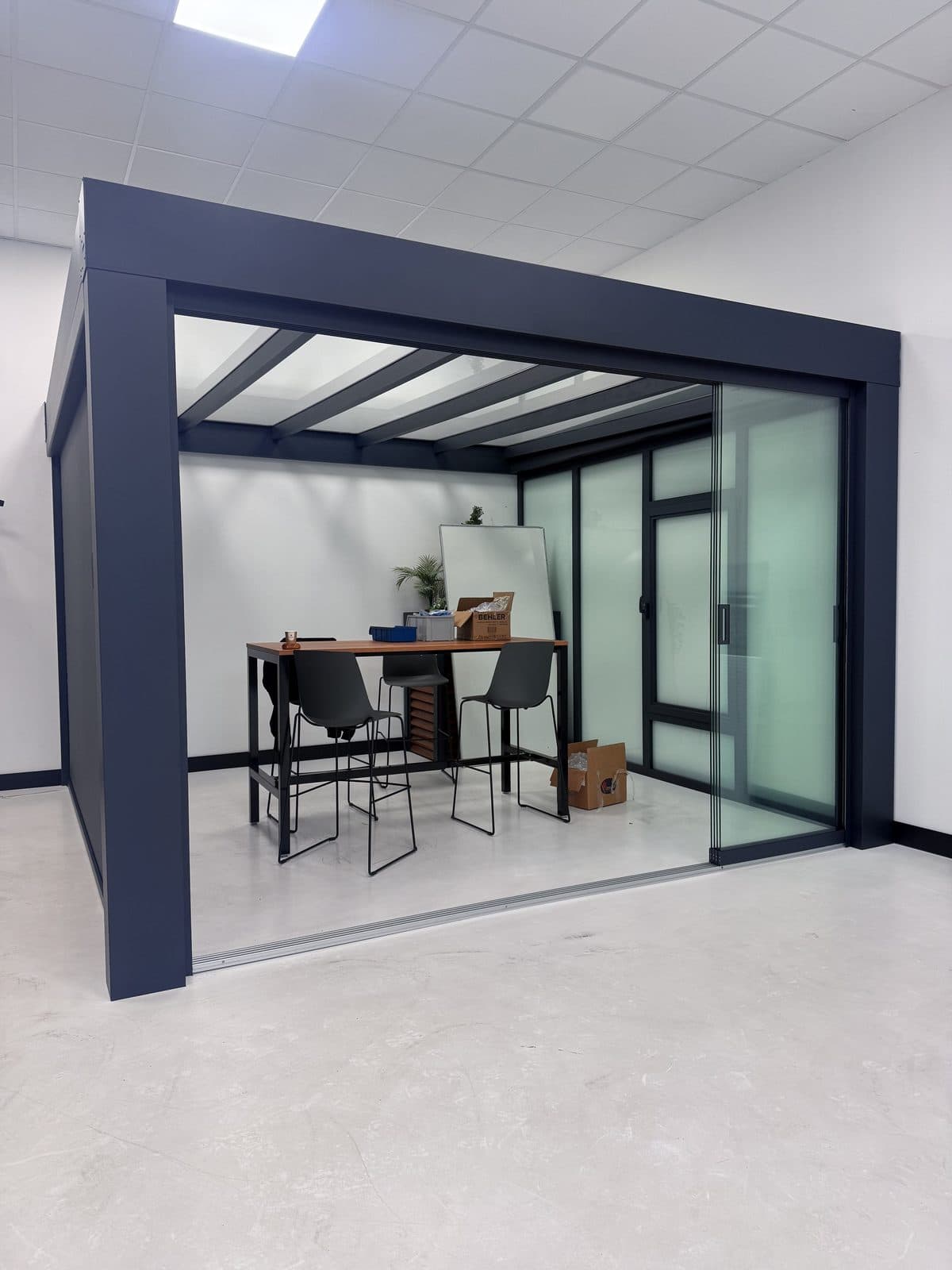 Antraciet overkapping met glazen schuifwanden in de showroom